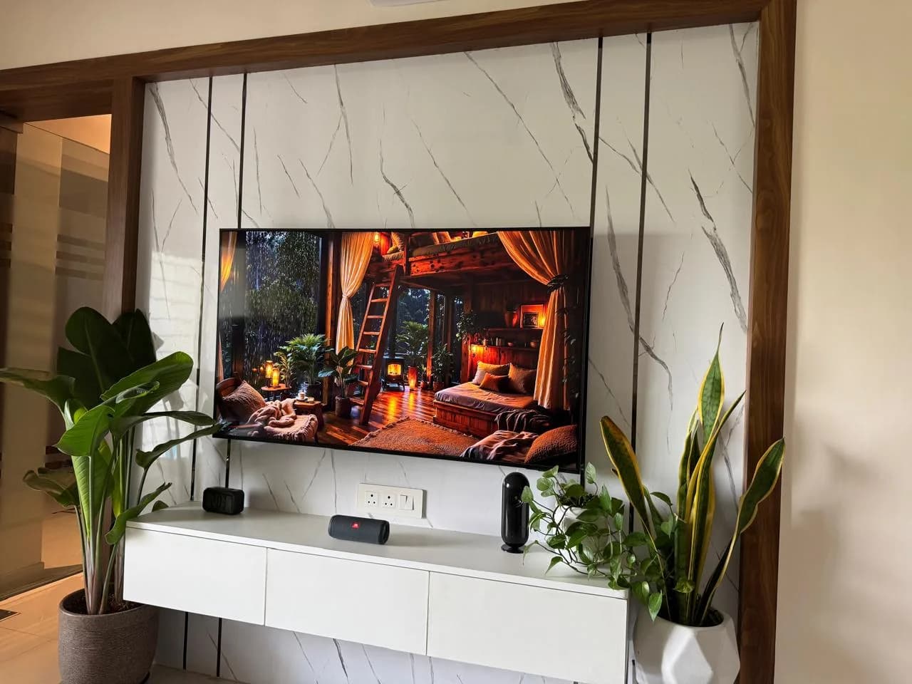 Delivered marble TV panel set in a wooden frame with a floating console — 3 BHK interior, Rohan Abhilasha, Lohegaon