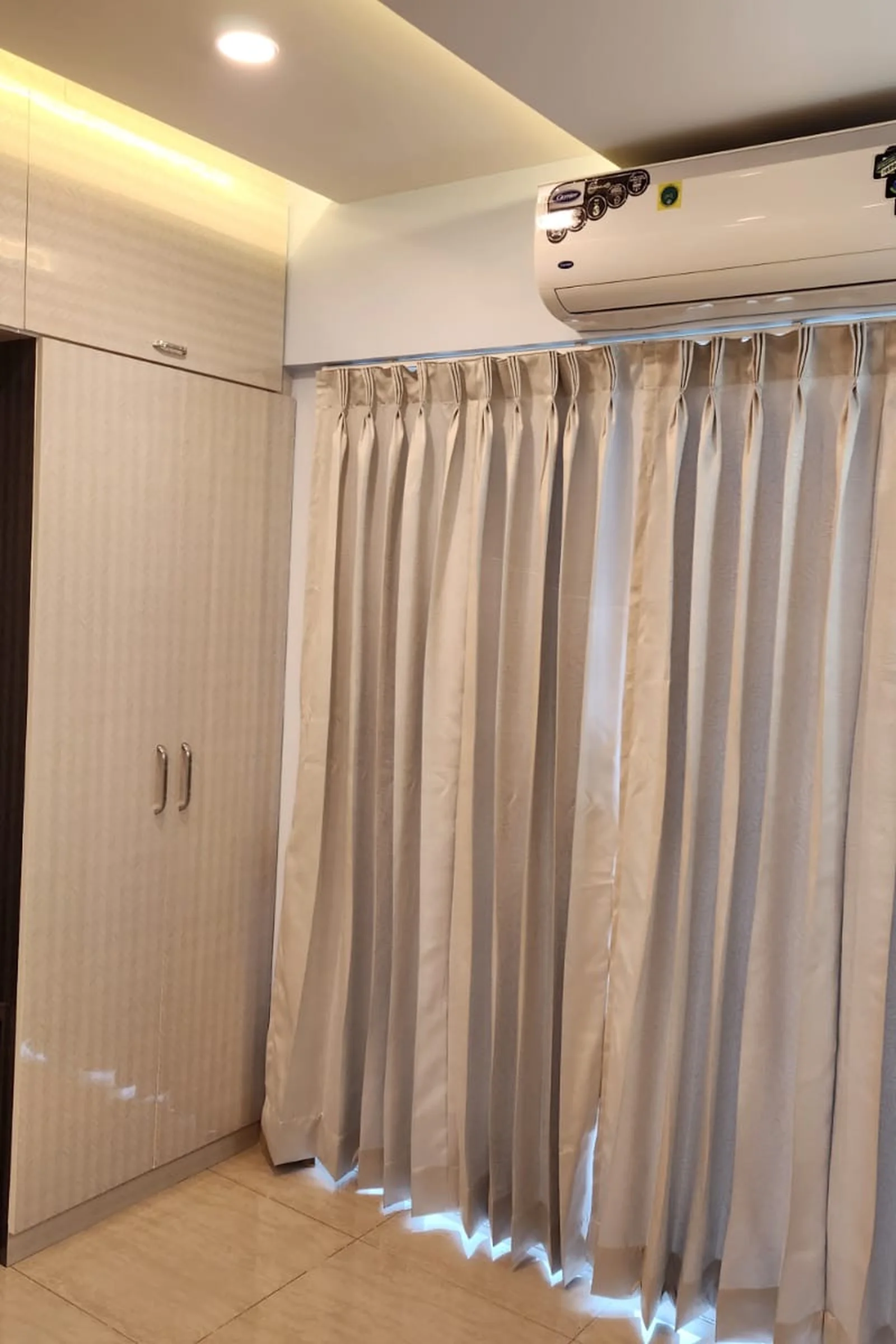 Floor-to-ceiling fitted wardrobe run with loft storage above in a Pune bedroom